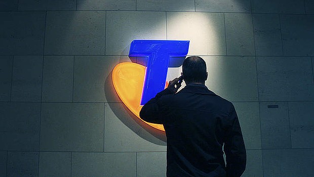 Telstra logo with man holding phone